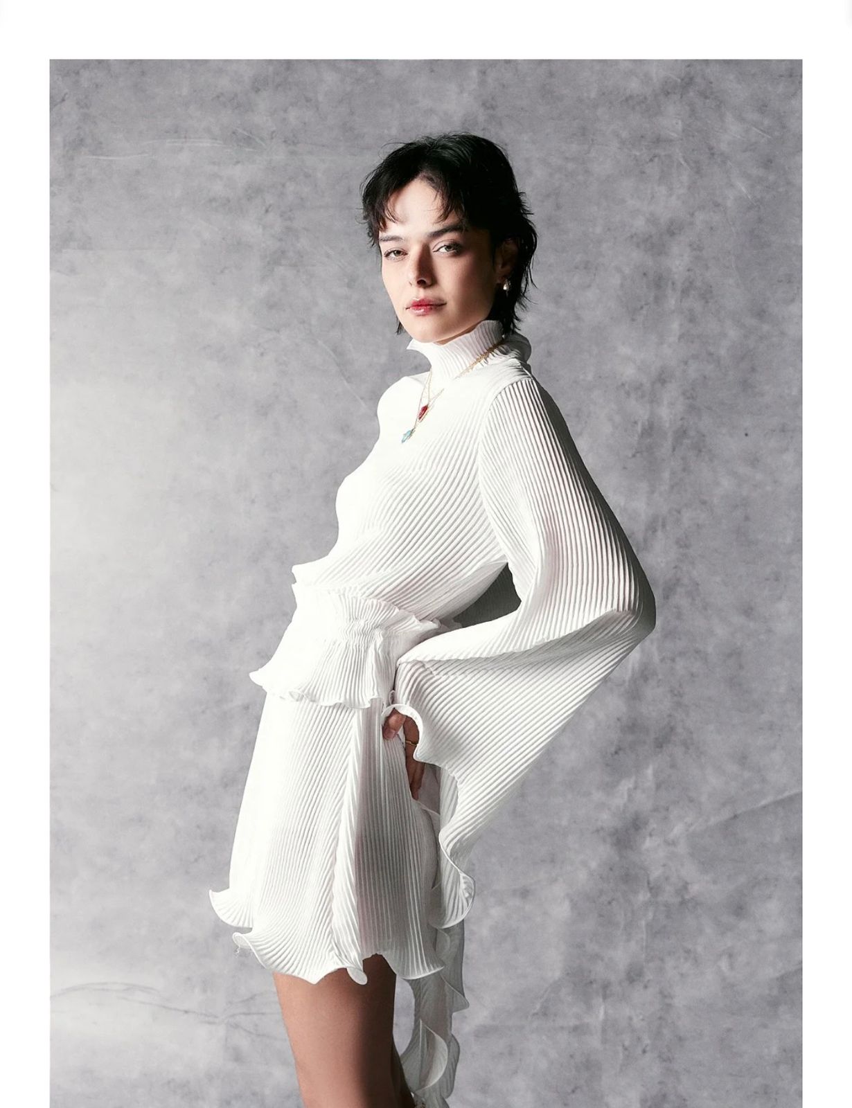 Vestido curto branco plissado com mangas longas e gola alta